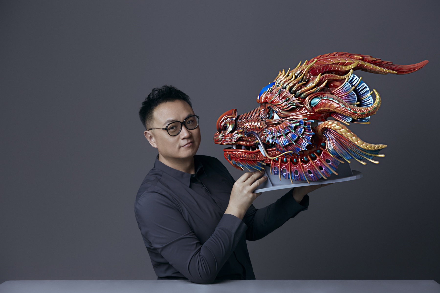 Xiao Di, known as Master X, holding a mechanical dragon artwork